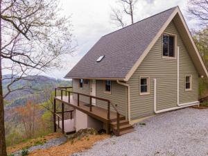 a tiny house with a porch on a hill at Calling Me Home in Lenoir