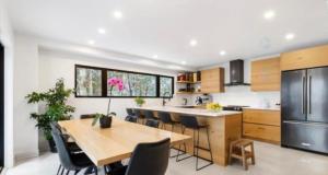 a kitchen with a wooden table and chairs and a refrigerator at Chalet ouareau in Saint-Donat-de-Montcalm