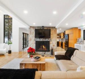 a living room with a couch and a fireplace at Chalet ouareau in Saint-Donat-de-Montcalm