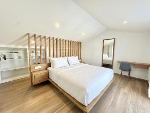 a bedroom with a large white bed and a mirror at Balcón da Ría in Cambados +43 photos