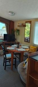 a living room with a table and a couch at Stay 6 - Pool - Parking - BeachSide - Pet Friendly in Trimingham