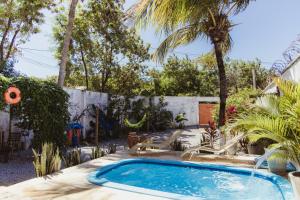 a swimming pool in a yard with palm trees at CASA DA PIPA in Pipa