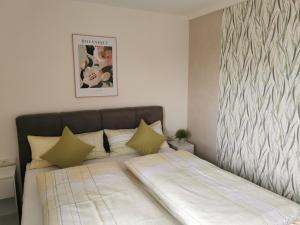a small bedroom with a bed with green pillows at Ferienwohnung DORFWIESE in NuÃŸbaum