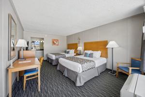 a hotel room with two beds and a desk at Beachside Motel - Amelia Island in Amelia Island