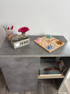 a table topped with a shelf with a table with a home sign at Appart Résidence Yadah RDC in Granville +6 photos