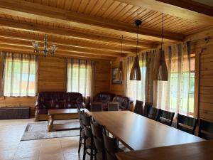 a dining room with a table and chairs at Piliakalnio Sodyba in Ilgininkai