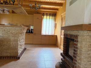 a living room with a stone fireplace in a house at Piliakalnio Sodyba in Ilgininkai +56 photos