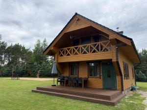 a log cabin with a table and chairs in a yard at Piliakalnio Sodyba in Ilgininkai