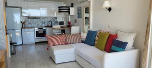 a living room with a white couch with colorful pillows at Costa Plana apartment with terrace and sea view in Cap d'Ail