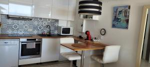 a small kitchen with a table and a microwave at Costa Plana apartment with terrace and sea view in Cap d'Ail