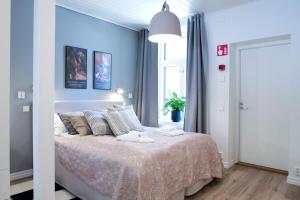 a bedroom with a large bed with blue walls at Hotel Amandis in Naantali