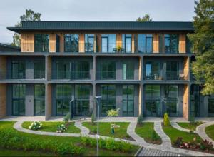 a large building with a garden in front of it at La Tereza Apartments in Ķesterciems +21 photos