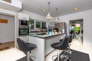 a kitchen with black chairs at a counter at Organic Gardens Villa in Crikvenica