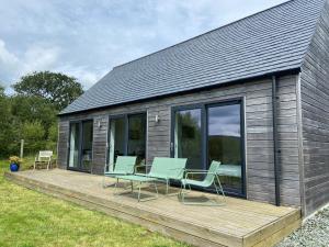 a wooden deck with chairs and a house at Achnacolain Lodge in Tarbert
