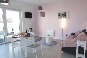 a white living room with a table and a couch at Grand studio La Sensée - Parking privé, Terrasse, Netflix, au calme in Hem-Lenglet