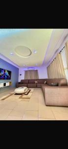 a living room with a couch and a tv at Rach in Komé