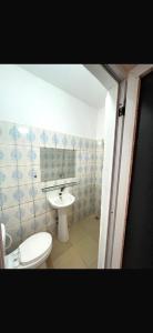 a bathroom with a toilet and a sink at Rach in Komé