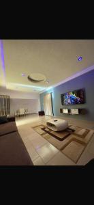 a living room with a couch and a flat screen tv at Rach in Komé