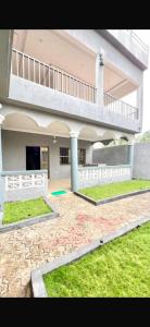 a large building with a balcony and a yard at Rach in Komé
