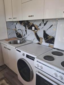 a kitchen with a stove and a sink at Vila zvjezda 2 in Jajce