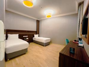 a bedroom with a bed and a desk and a tv at فندق أوركيد مكة in Mecca +31 photos