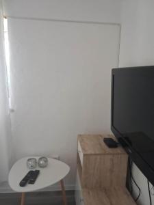 a living room with a white table and a flat screen tv at Vila zvjezda 2 in Jajce