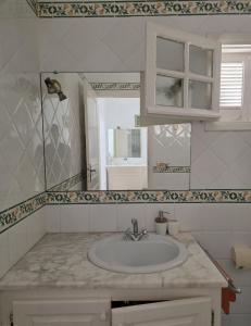 a bathroom with a sink and a mirror at Antique seaside appartement in Mahdia +6 photos