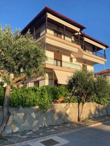a large building with trees and a stone wall at Villa Eleon 1 in Nea Vrasna