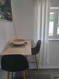 a wooden table with a bowl on top of it next to a window at Vila zvjezda 2 in Jajce +7 photos