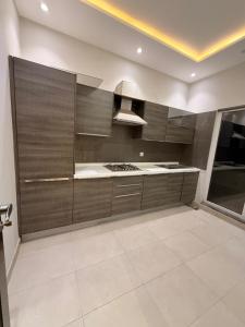 a kitchen with brown cabinets and a white tile floor at Private villa in Lahore