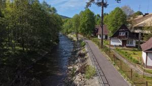 a river in a village with houses and a road at Domek Beskid Żywiecki in Rycerka Dolna