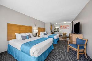 a hotel room with two beds and a flat screen tv at Beachside Motel - Amelia Island in Amelia Island +17 photos