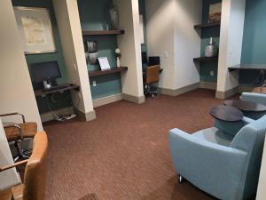 a waiting room with blue chairs and a tv at Domain at Kirby in Houston +12 photos