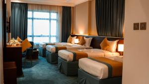 a hotel room with four beds and a window at فندق الكنارى ان in Mecca +51 photos