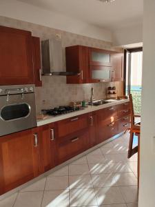 a kitchen with wooden cabinets and stainless steel appliances at Casa Vacanze Daniele in Pontecagnano