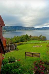 a bench in a field with a view of a lake at Domos lago Muisca Xue in Aquitania
