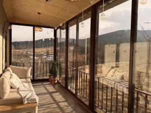 Eine überdachte Veranda mit Sofa und Blick auf die Berge in der Unterkunft Tesaran Stepanavan Guest House, Apart Hotel in Stepanawan