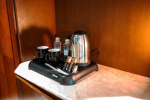 a coffee maker sitting on a counter with two cups at فندق الكنارى ان in Mecca