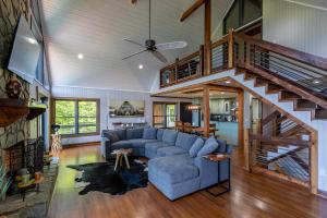 a living room with a blue couch and a staircase at Rockcliff Retreat in Lenoir