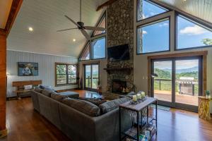 a living room with a couch and a stone fireplace at Rockcliff Retreat in Lenoir