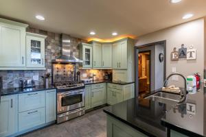 a large kitchen with blue cabinets and a sink at Rockcliff Retreat in Lenoir