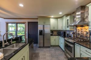 a kitchen with white cabinets and a stainless steel refrigerator at Rockcliff Retreat in Lenoir +33 photos
