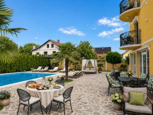 a patio with a table and chairs next to a pool at Vila Kristina in Negotin