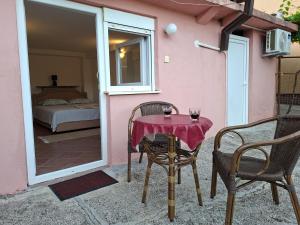 a table with two chairs and a table with wine glasses at Apartman Pavle 2 in Virpazar