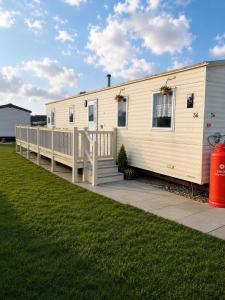 a mobile home with a porch and a deck at Beachside 3 Bed Caravan with Deck & Outside Seating Mablethorpe in Mablethorpe