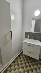 a white bathroom with a sink and a mirror at La casa de valras in Valras-Plage +21 photos