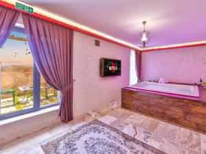 a bath tub in a room with a window at Noble Crown Stone House Cappadocia in Uçhisar