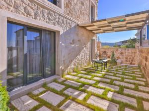 a patio with a table and chairs on the side of a building at Noble Crown Stone House Cappadocia in Uçhisar