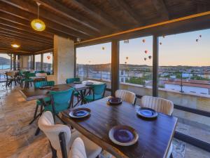 a restaurant with tables and chairs and large windows at Noble Crown Stone House Cappadocia in Uçhisar