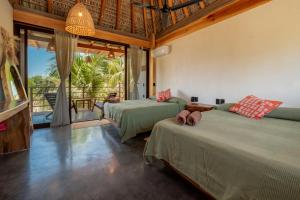 a bedroom with two beds and a large window at Punta Arena Surf Suites in Puerto Escondido